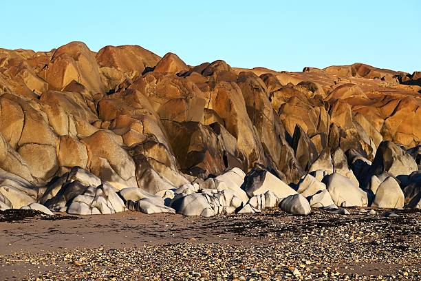 Seemingly watercolor painted rock formations rise over the beach along Hudson Bay in the Churchill Wildlife Management Area, Manitoba.