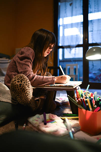 istock Child drawing and learning at home by lamp light 2251603905