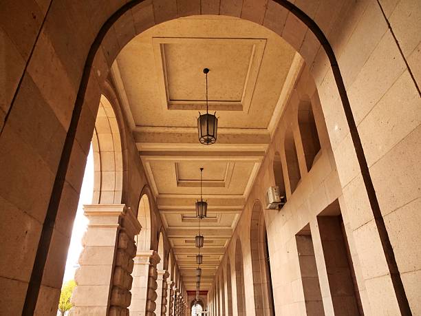 istock r view of a long, stone arcade with a vaulted, coffered ceiling andvintage lantern-style hanging lights. 2251607186