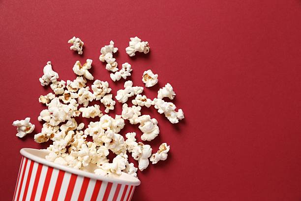 istock Delicious popcorn in a striped cardboard basket on a colored background 2251608139