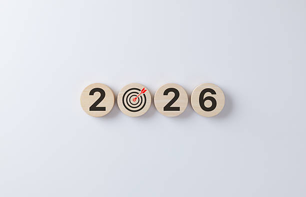 New year 2026 goal setting concept. Wooden circles with numbers and target icon symbolizing business planning, future objectives, mindset, resolution strategy and success vision on white background.