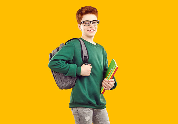 istock Smiling handsome teenage boy with backpack holding books 2251609929