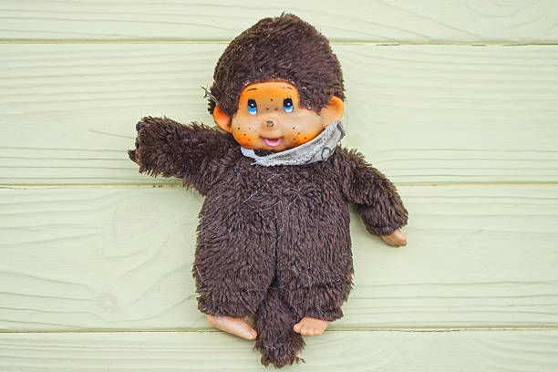istock brown plush toy monkey lies on a yellow table 2251616756