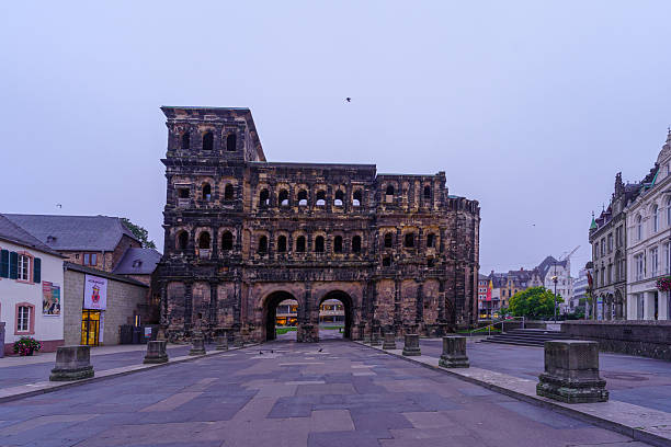Trier, Germany - October 12, 2024: Foggy sunrise view of the Porta Nigra, a Roman era city gate, in Trier, Rhineland-Palatinate, Germany