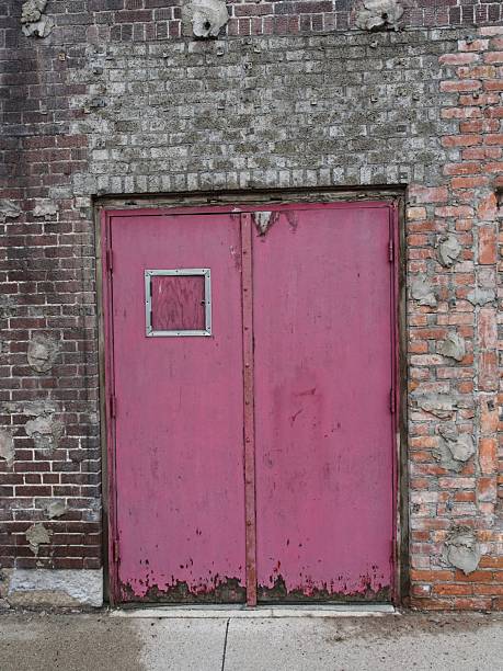 istock Red door set into an old brick wall a design element 2251624095