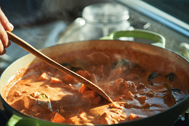 istock Preparing Thai Red Curry Served with Basmati Rice in Domestic Kitchen 2251624776