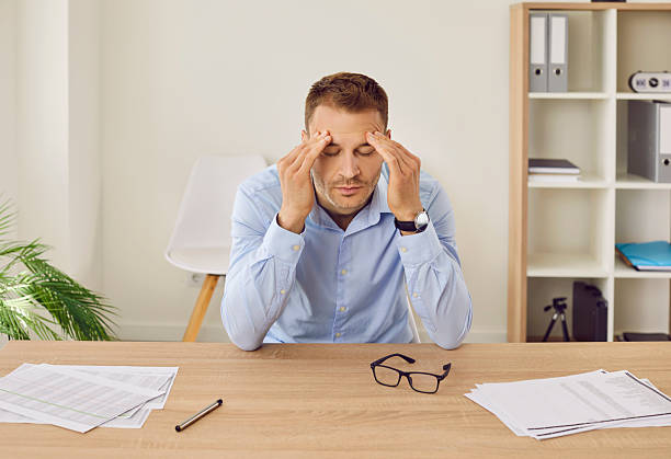 istock Stressed, tired, overworked business man suffering from headache at work in the office 2251633476