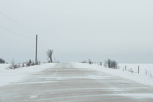 Blowing snow covers a road in Ontario during a winter storm.