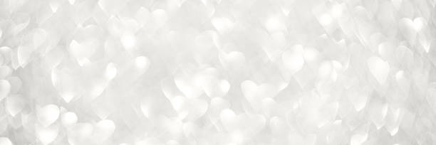 Soft white heart-shaped bokeh light background for romantic and elegant themes