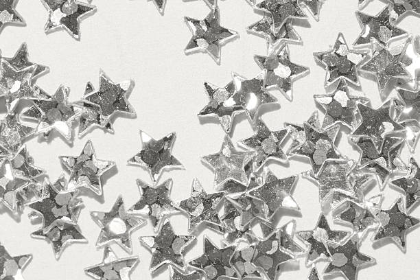 istock Sparkling silver star confetti scattered on white background for festive celebration and decoration 2251637101