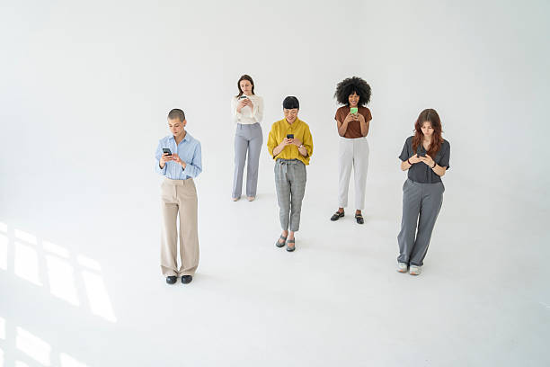 istock Five young businesswomen using their smartphones on white background 2251640258