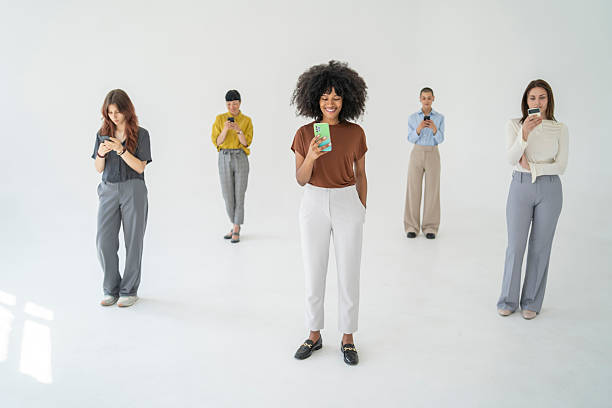 istock Five young businesswomen using their smartphones on white background 2251640259