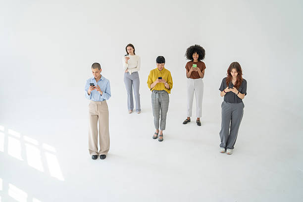 istock Five young businesswomen using their smartphones on white background 2251640261