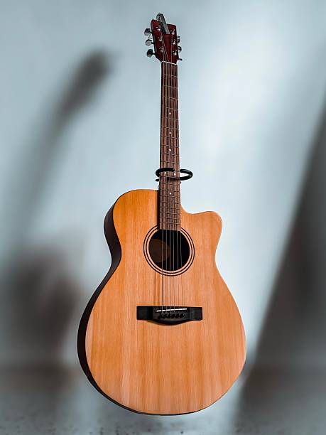 istock Acoustic guitar standing alone on minimalist background 2251648658