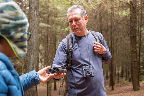 istock Grandfather teaching grandson about nature, birdwatching, and sharing binoculars in forest 2251661009