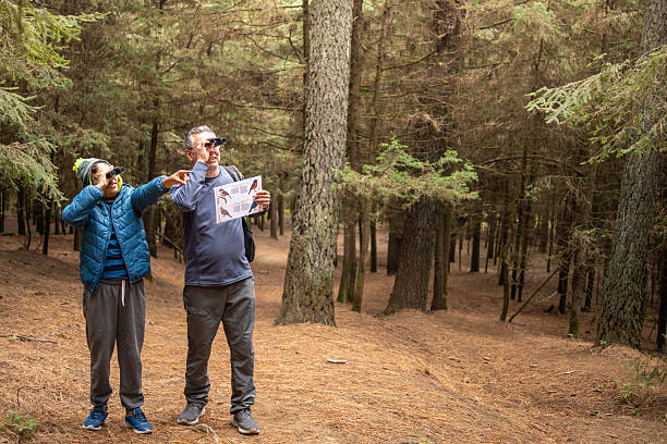 istock Grandfather and grandson birdwatching in forest with binoculars and bird guide 2251661054