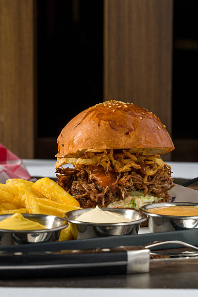 Slow-cooked beef brisket burger served with fries and sauces