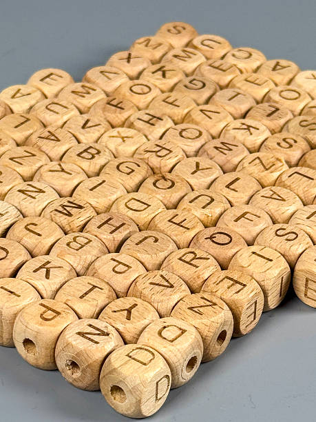istock Wooden beads with letters arranged in a grid pattern on a flat surface 2251666699