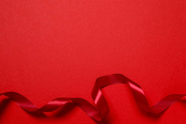 istock Red silk ribbon on color background 2251679594