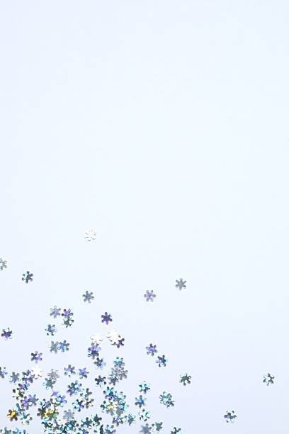 istock Beautiful silver snowflake-shaped confetti on a white background 2251679826