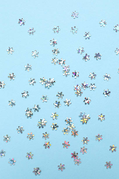 istock Beautiful silver snowflake-shaped confetti on a color background 2251679851