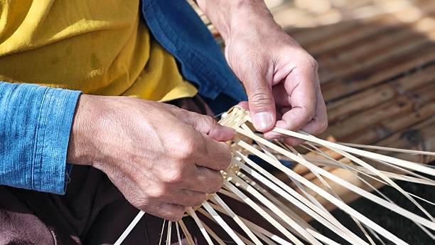istock Hands weaving natural materials. Crafting bamboo basket. Basketry, basketwork or wickerwork. 2251685957