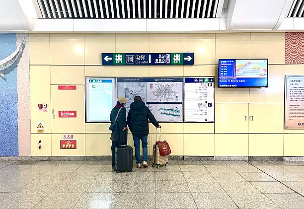 2025.11.24, Beijign, China. Beijing Subway Line 8 Jinyu Hutong Passengers Check the Map Around.