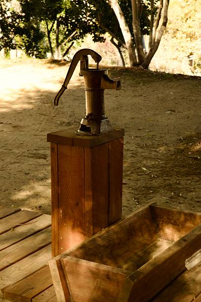 istock Old fashioned water pump and trough 2251689213