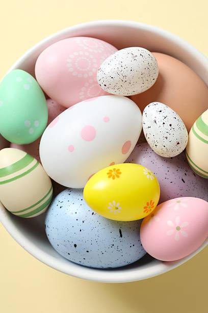 istock Happy Easter. Colorful eggs in a bowl on beige background, space for text or advertising 2251689831