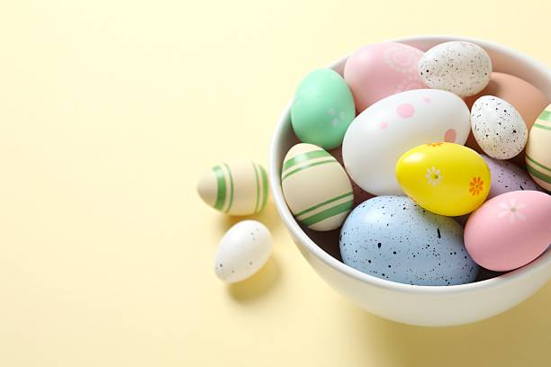 istock Happy Easter. Colorful eggs in a bowl on beige background, space for text or advertising 2251689834