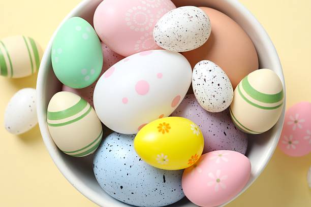 istock Happy Easter. Colorful eggs in a bowl on beige background, space for text or advertising 2251689854