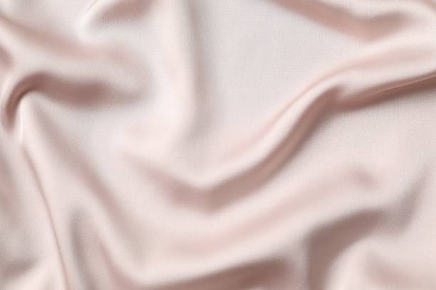 istock Beige silk satin. Shiny smooth fabric. Soft folds. Luxury background with space for design. Flat table, top view 2251690000