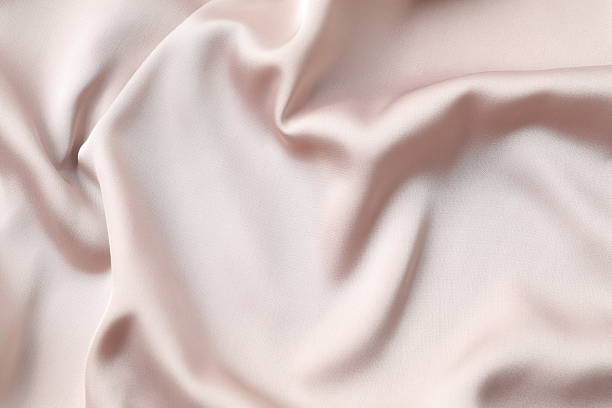 istock Beige silk satin. Shiny smooth fabric. Soft folds. Luxury background with space for design. Flat table, top view 2251690024