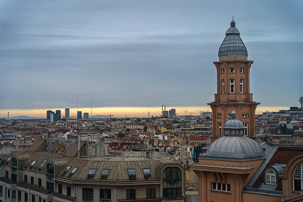 Vienna, Austria - October 4, 2025 - Urban skyline with a tower and cloudy skies over city rooftops.