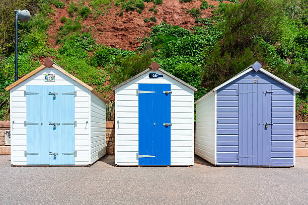 istock Three colourful beach huts in coastal setting in Sidmouth, Devon, with bright pastel doors and lush greenery 2251693770