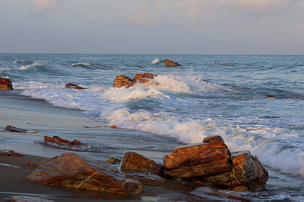 Early morning in Jericoacoara east beach. Blue sea water and white foam on waves  crest