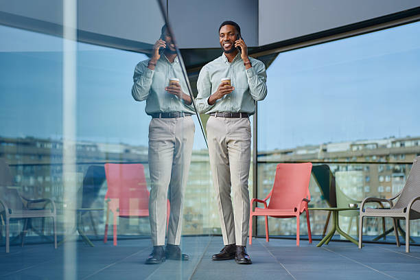 istock Business man talking on phone with coffee on urban balcony 2251696759