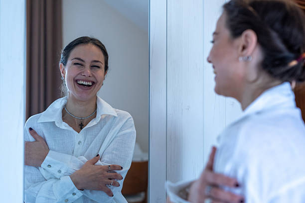 istock Woman smiling and laughing at mirror reflection. Stock image 2251699167