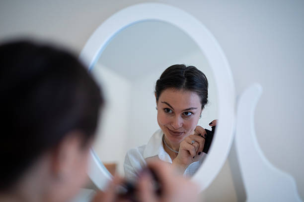 Young woman applying make-up. About 25 years old, Caucasian brunette.