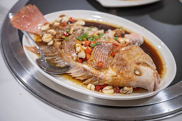 Tender steamed fish served with a fragrant ginger and soy sauce dressing, showcasing a healthy, flavorful, and traditional Chinese dish.
