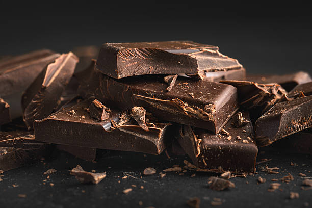 istock Dark chocolate bar pieces stacked on dark background 2251706551