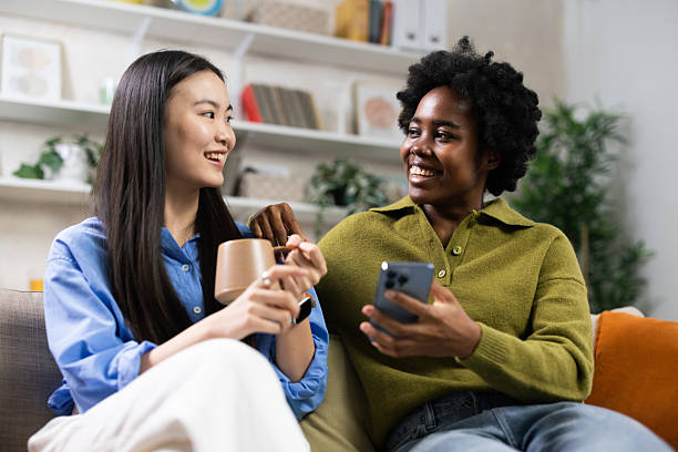istock Diverse young women smiling talking on couch 2251710804