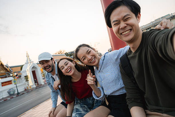 istock Group of friends taking pictures and filming themselves with digital camera while exploring the city of Bangkok 2251713221
