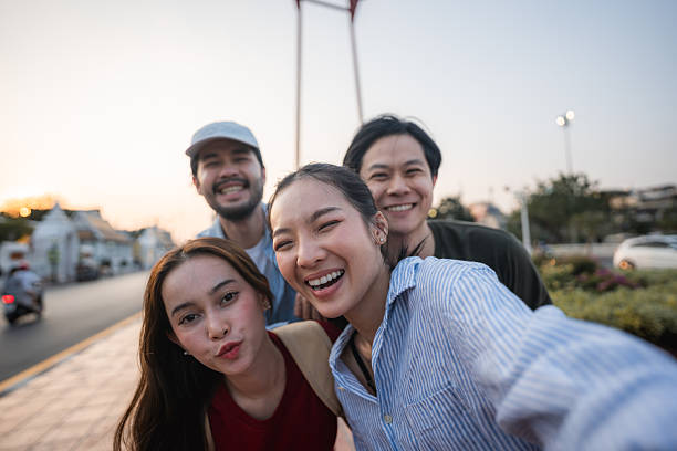 istock Group of friends taking pictures and filming themselves with digital camera while exploring the city of Bangkok 2251713266