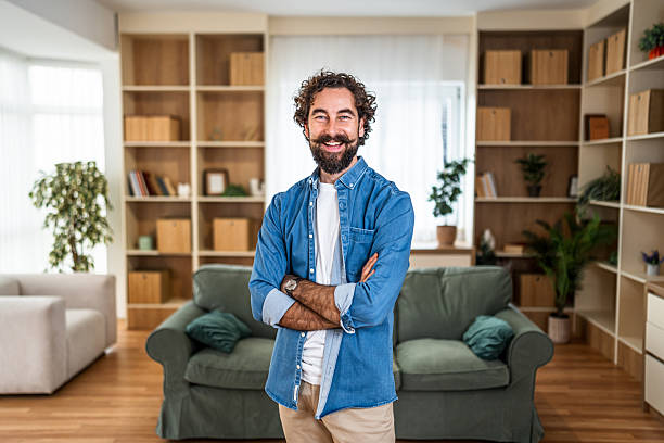 istock Man smiling with arms crossed at home 2251716120