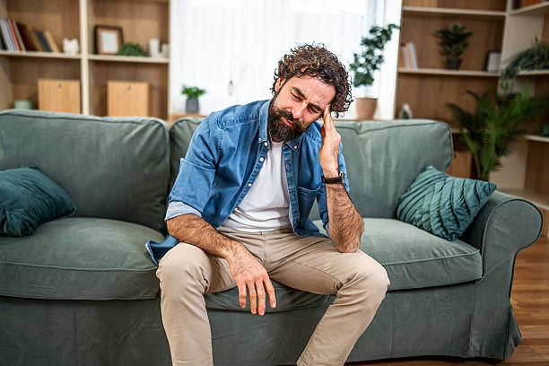istock Man suffering from headache and stress at home 2251716187