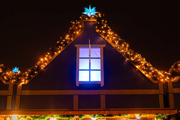 Festively decorated Christmas market hut with warm lights, a glowing blue star and garlands illuminating the night.