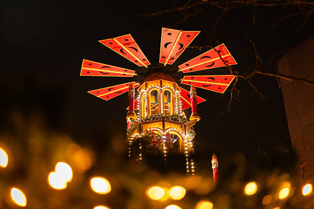 Traditional German Weihnachtspyramide glowing with warm lights during a holiday market.