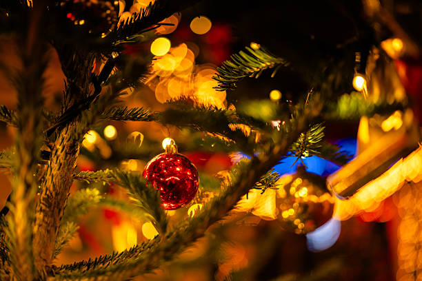 Close-up holiday detail showing the glow and texture of a golden Christmas ball.