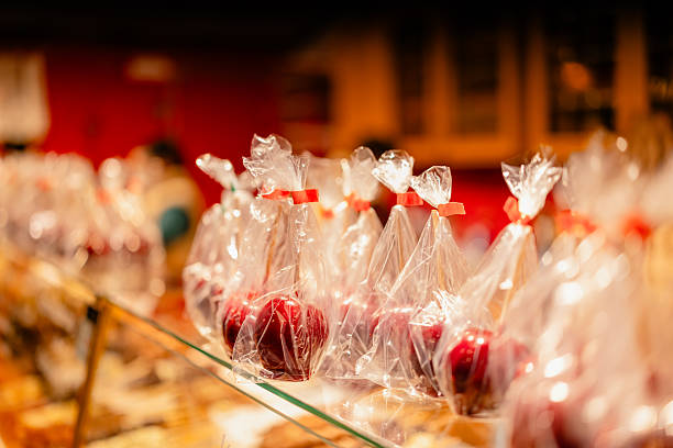 Red candy apples wrapped in plastic at Christmas market.